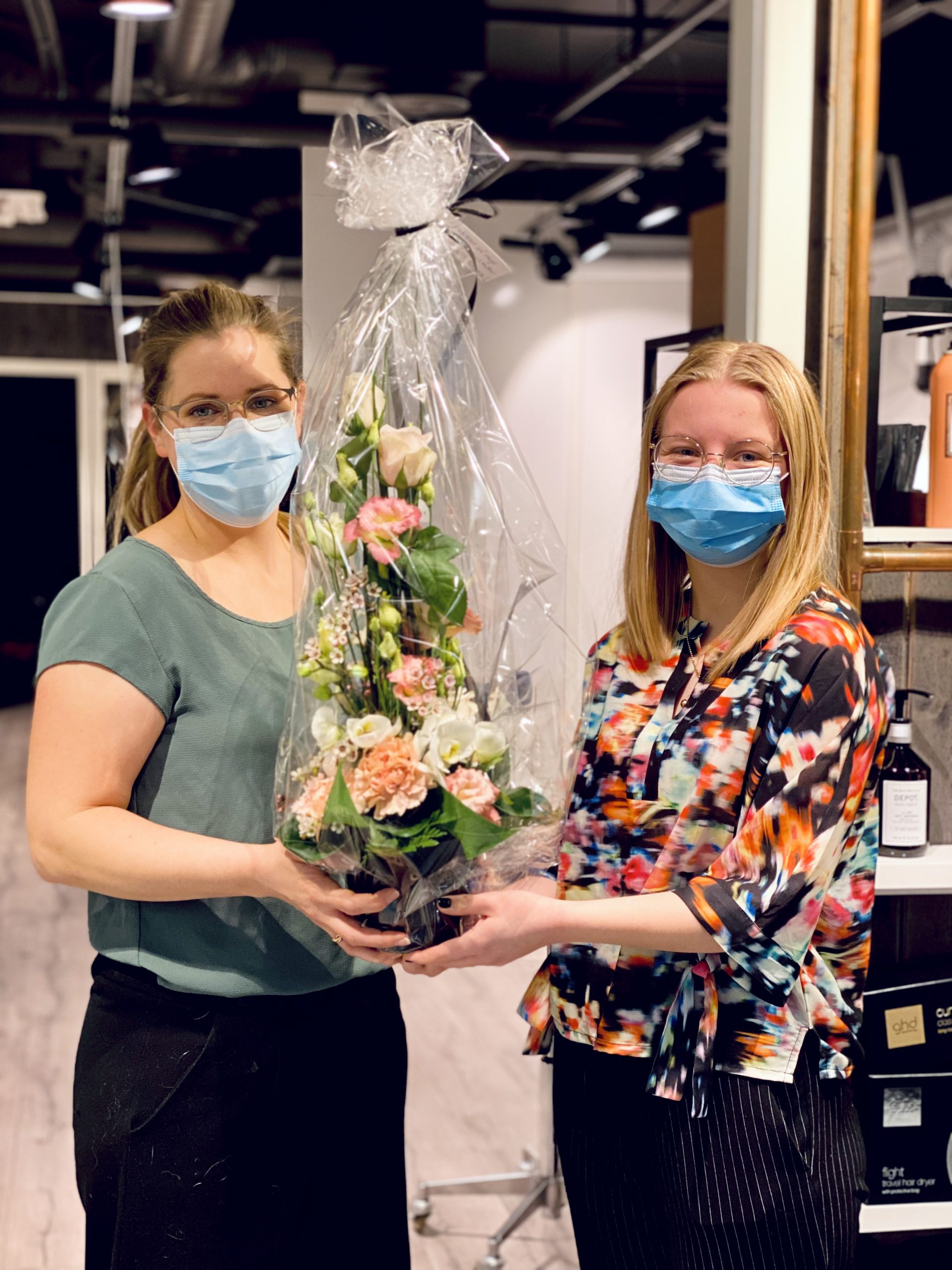 Årets butikk 2021, to frisører fra Glød som holder blomst som de har fått i gave fra senterkontoret