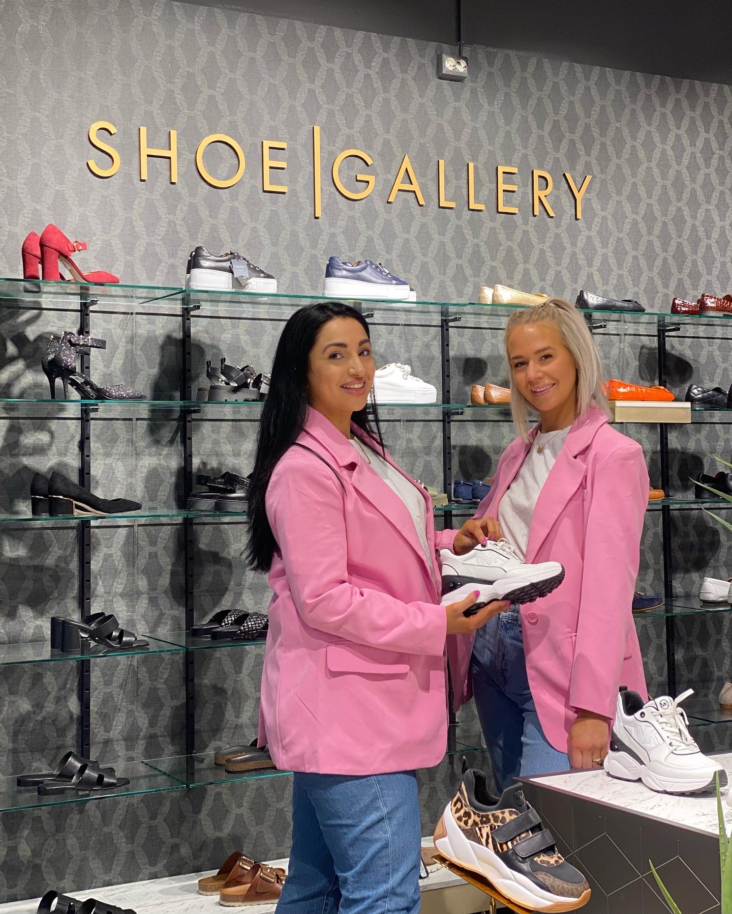 Butikksjef Jasmin og Iselin foran den nye Shoe Gallery veggen med nye sko