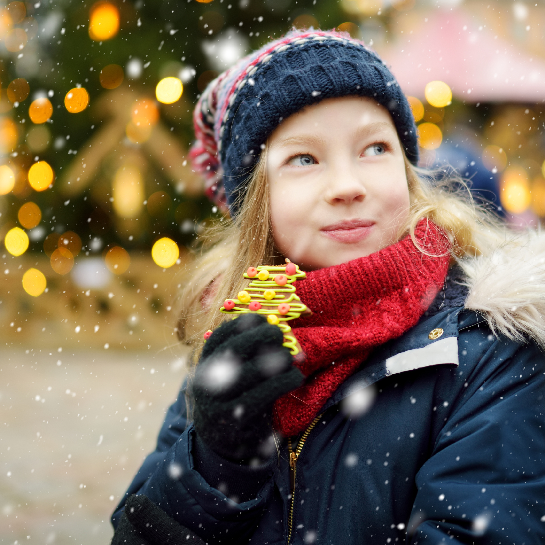 Jul på Lillestrøm Torv. Jente med lue og pepperkake i hånden.